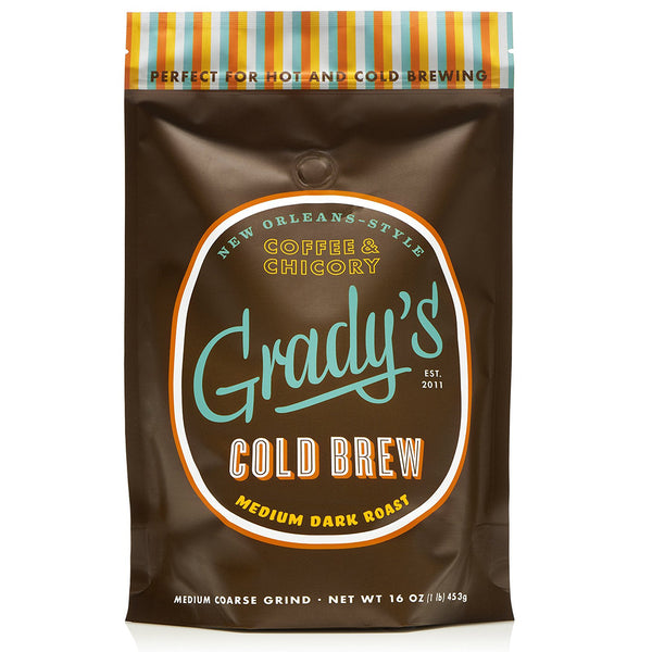Bag of Grady’s Cold Brew New Orleans-Style Coffee & Chicory, Medium Dark Roast. The 16 oz bag features a brown background with the Grady’s logo in light blue and orange, and a striped top edge in teal, orange, yellow, and brown. Text indicates it’s perfect for hot and cold brewing.